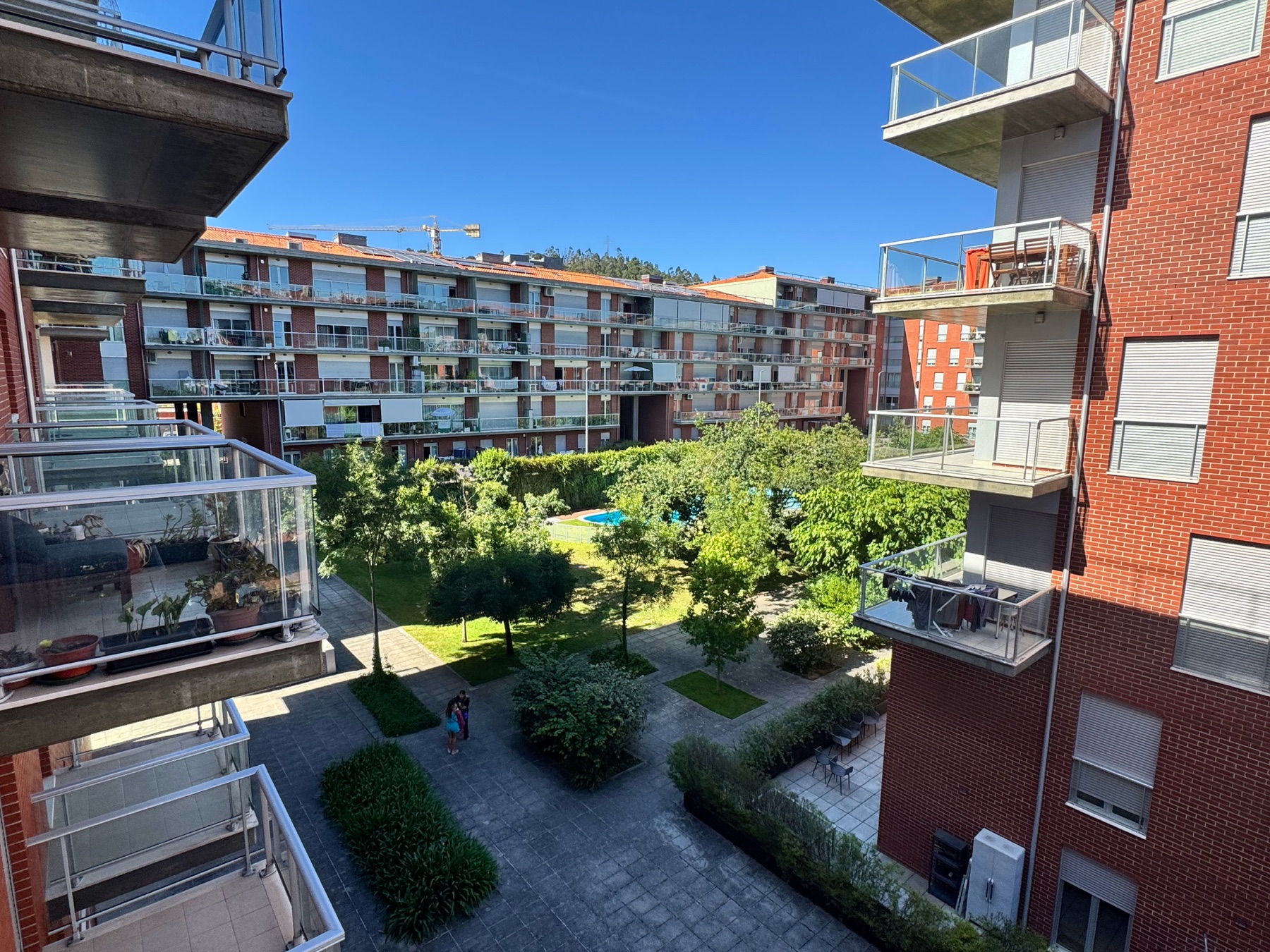 Vista do condomínio com jardim e piscina